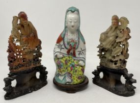 A Chinese figure of Guanyin, 23 cm high, and two carved soapstone figures (3)