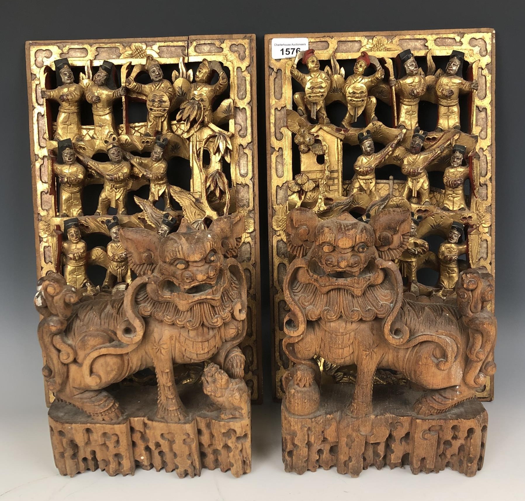 A pair of Chinese carved panels, decorated figures, highlighted in gilt, 40 x 25 cm, and a pair of