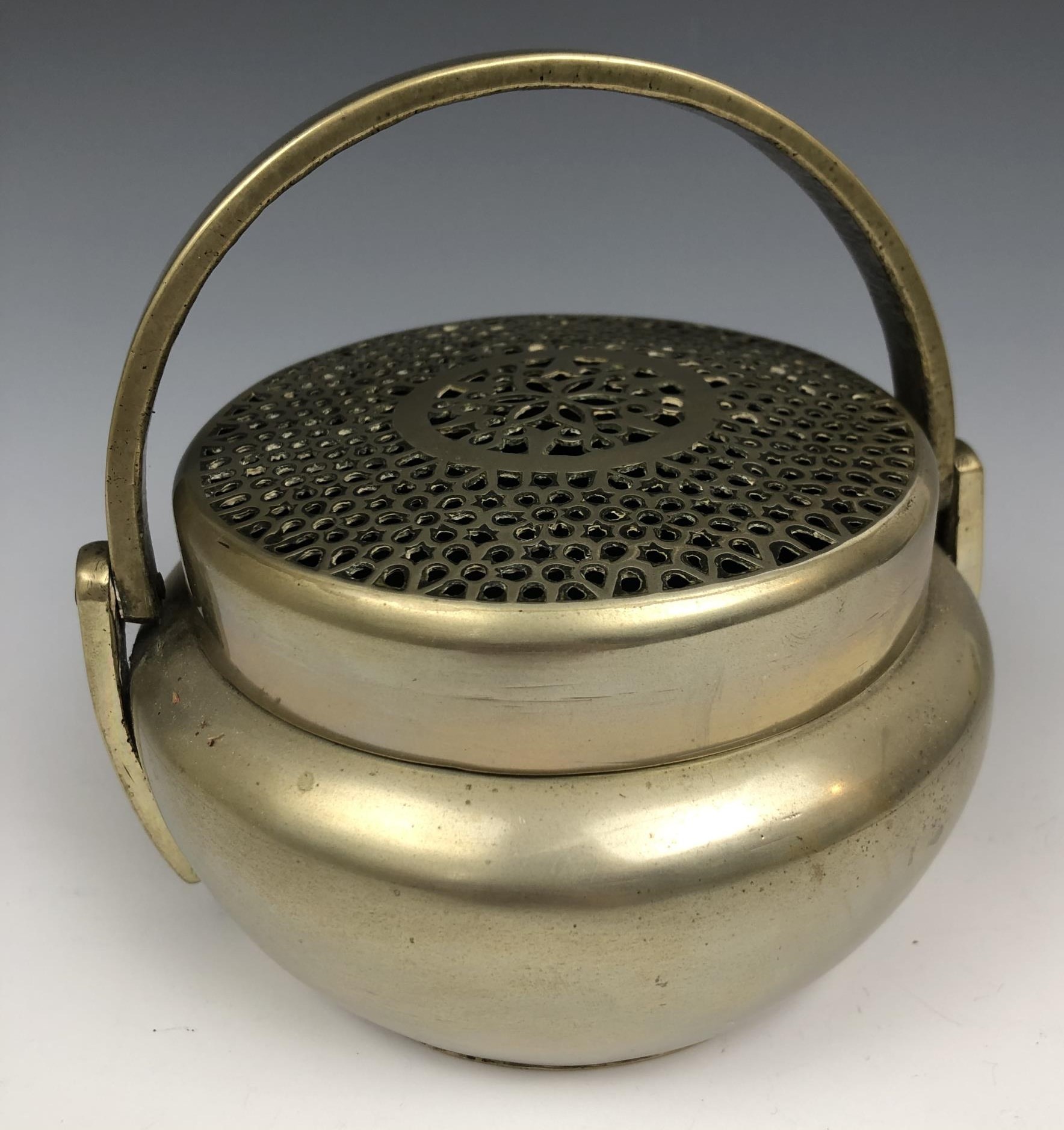 A Chinese metal censer and cover, with a swing handle, 12.5 cm diameter