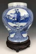 A Chinese blue and white vase, decorated figures, 20 cm high, on a carved wood stand A couple of