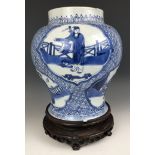 A Chinese blue and white vase, decorated figures, 20 cm high, on a carved wood stand A couple of