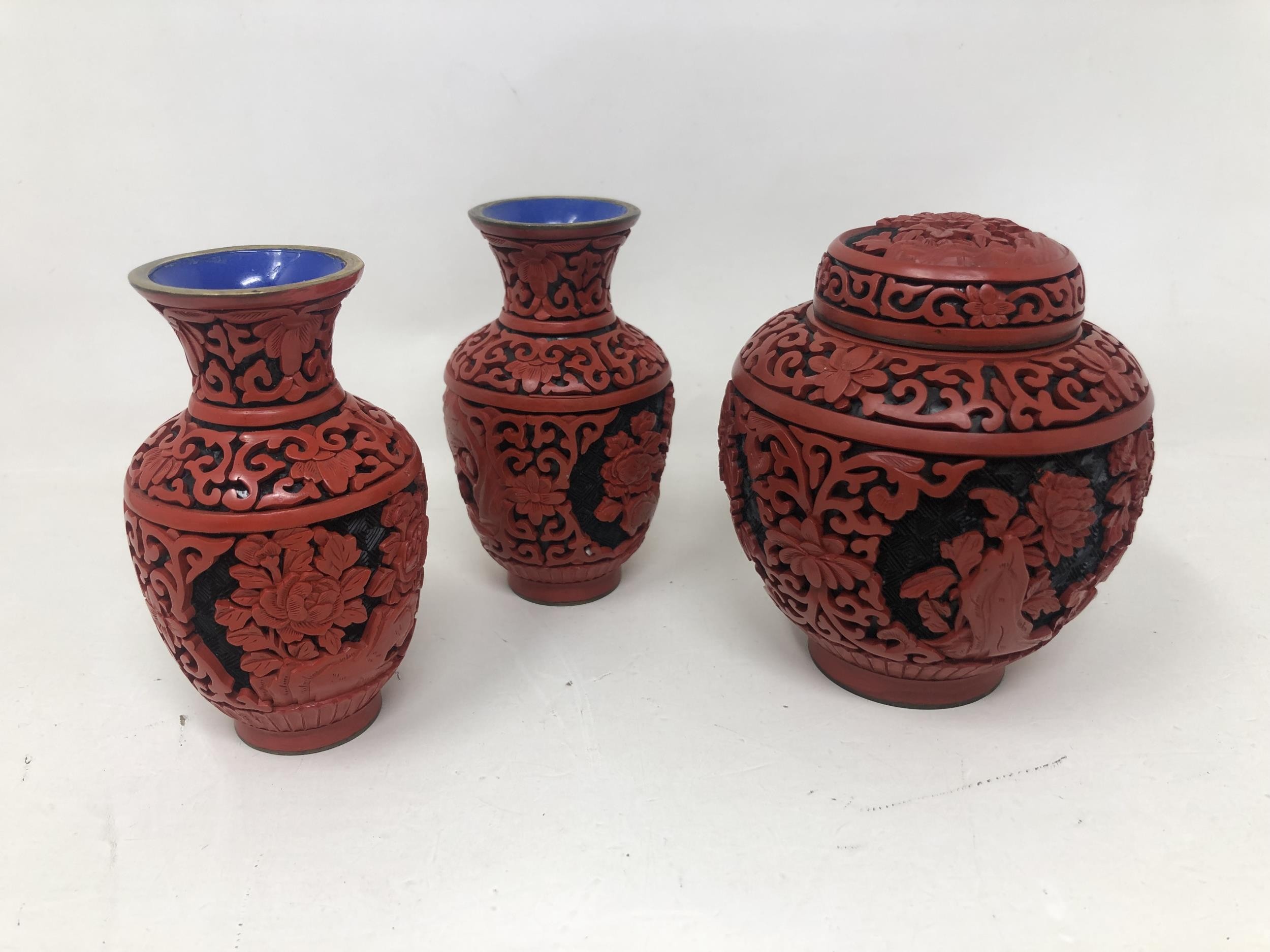 A pair of Chinese cinnabar lacquer vases, 10 cm high, and a matching jar and cover, 10.5 cm high (3)