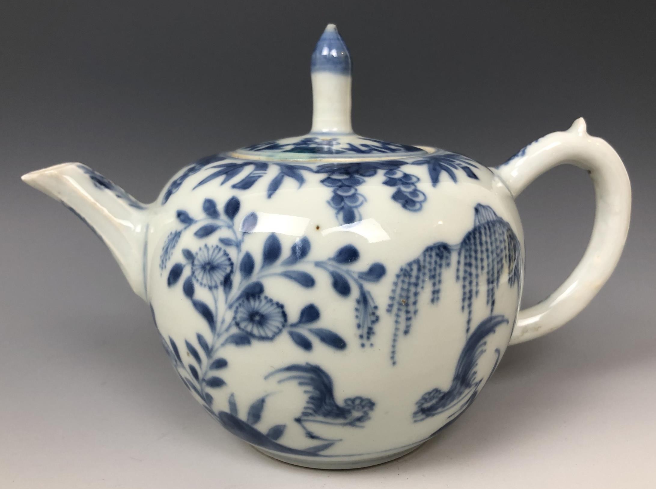 A Chinese teapot and cover, decorated birds, flowers and foliage in underglaze blue, 11.5 cm high