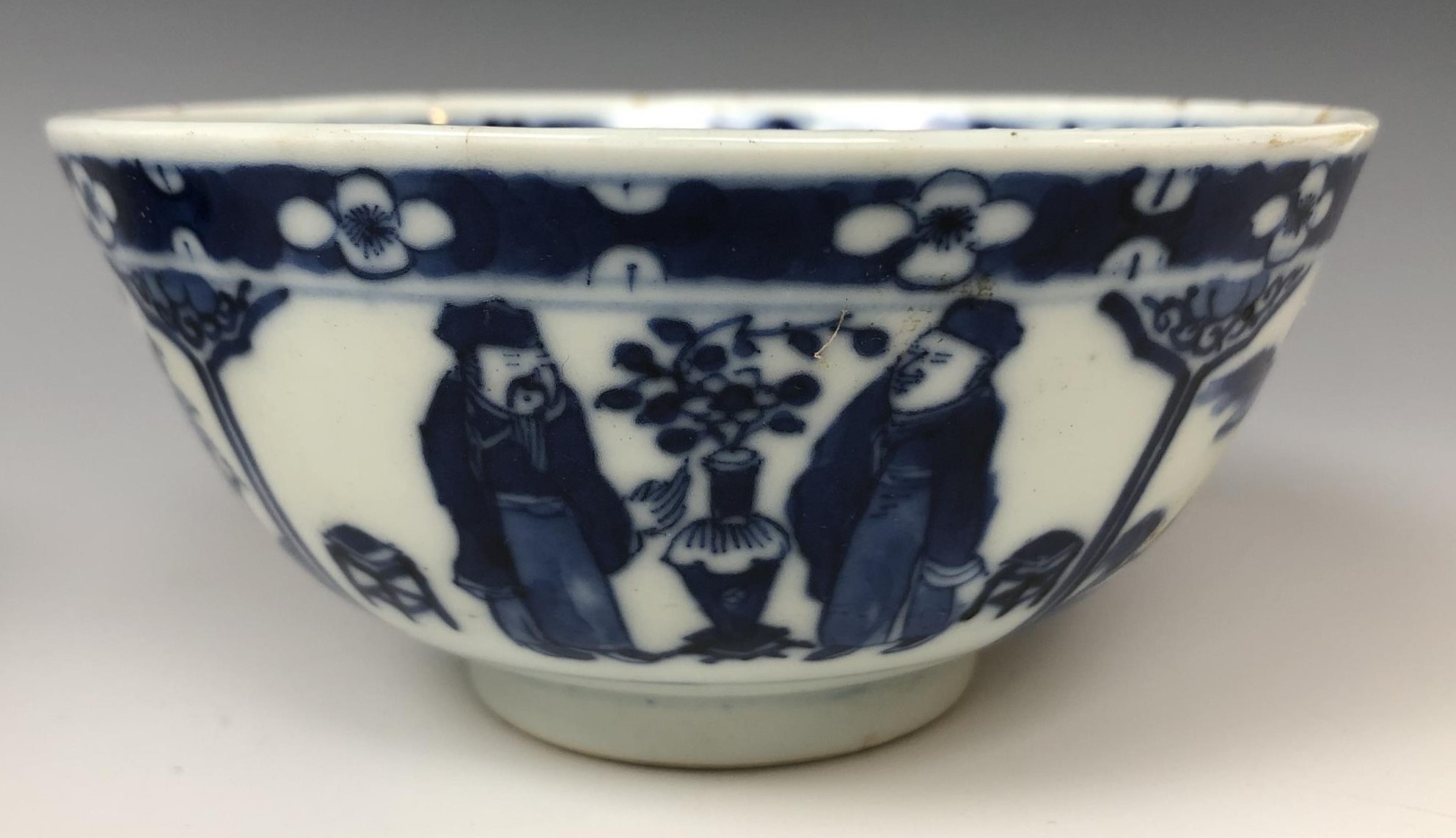 A pair of Chinese porcelain bowls, decorated panels of figures and landscapes in underglaze blue,