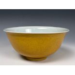 A Chinese porcelain yellow ground bowl, with incised decoration with dragons chasing flaming pearls,