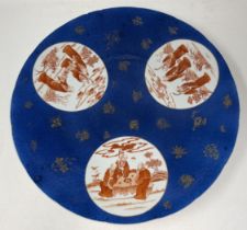 A Chinese powder blue charger, with three roundels, decorated figures in ironstone red, 40 cm