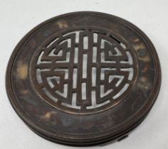 A Chinese bronze stand, with pierced decoration, on three feet, 18.5 cm diameter