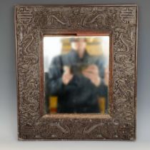 A Chinese wall mirror, with a carved wooden frame, decorated dragons, 49 x 39 cm