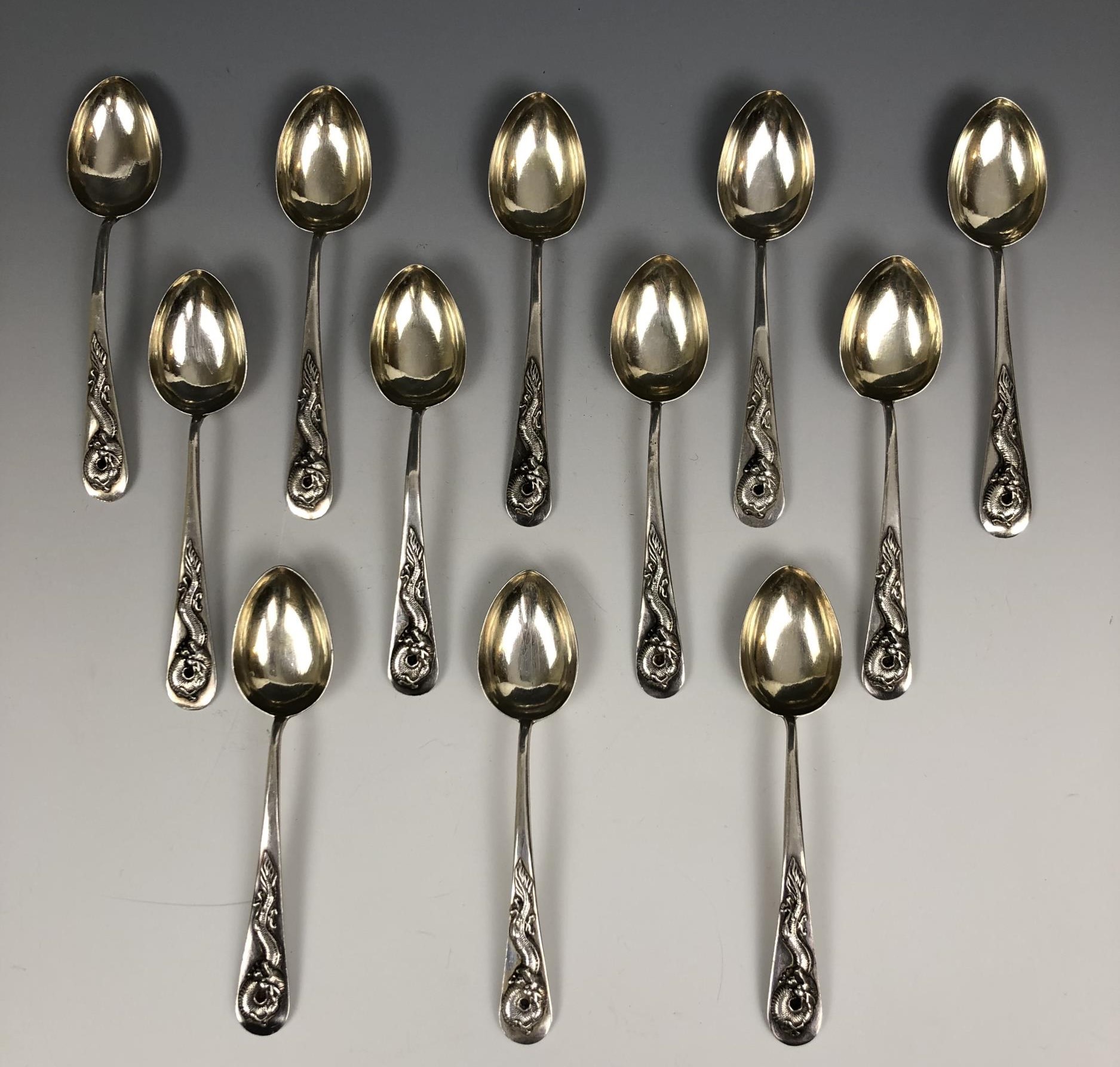 A set of twelve Chinese silver coloured metal spoons, the handles applied dragons, Wang Hing 5.0