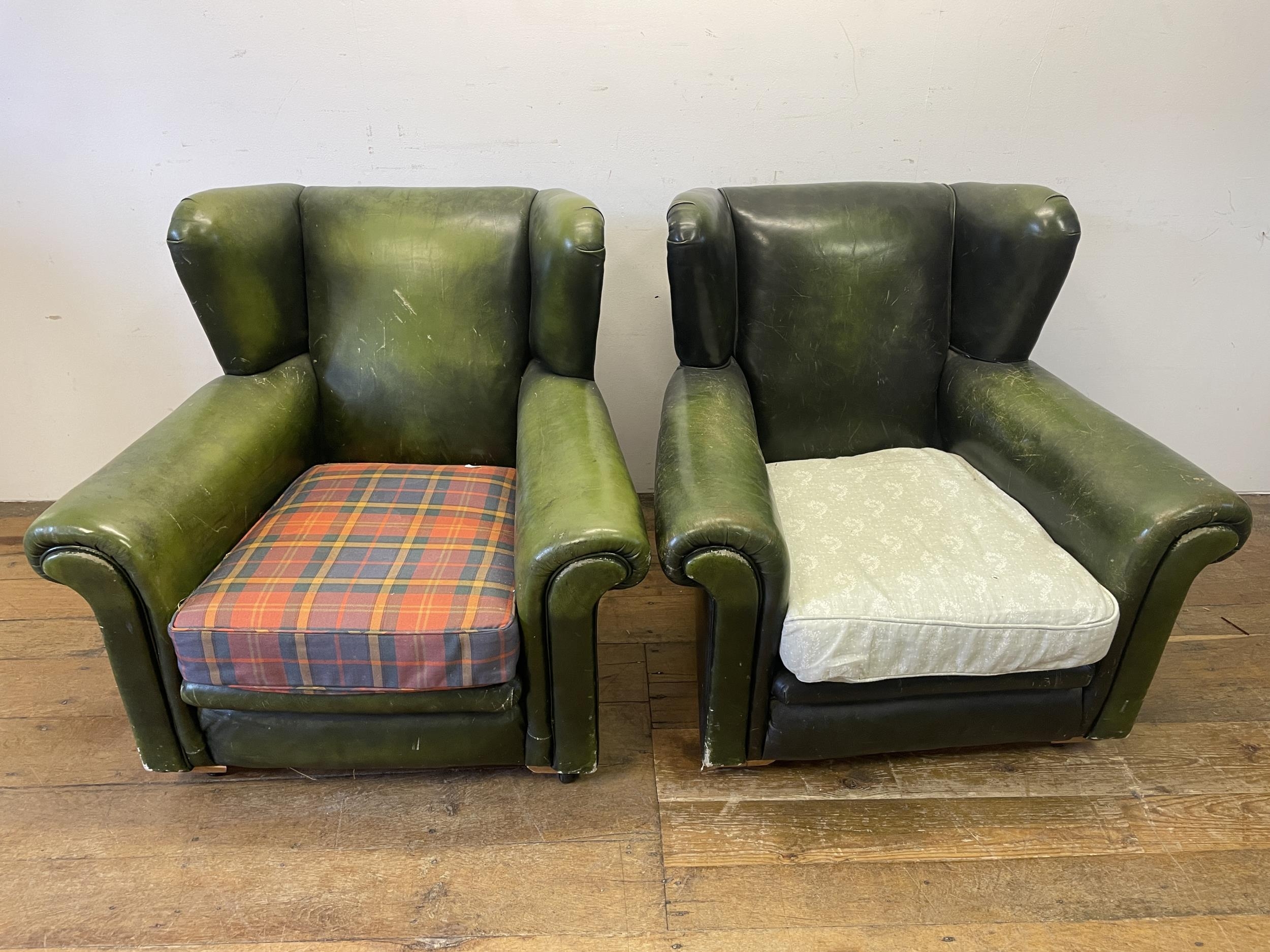 A pair of green leather armchairs, with later seats (2)