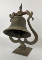 An early 20th century copper wall mounted bell, with a wrought iron mount and ringer, bell