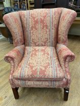 A wingback armchair, on mahogany legs