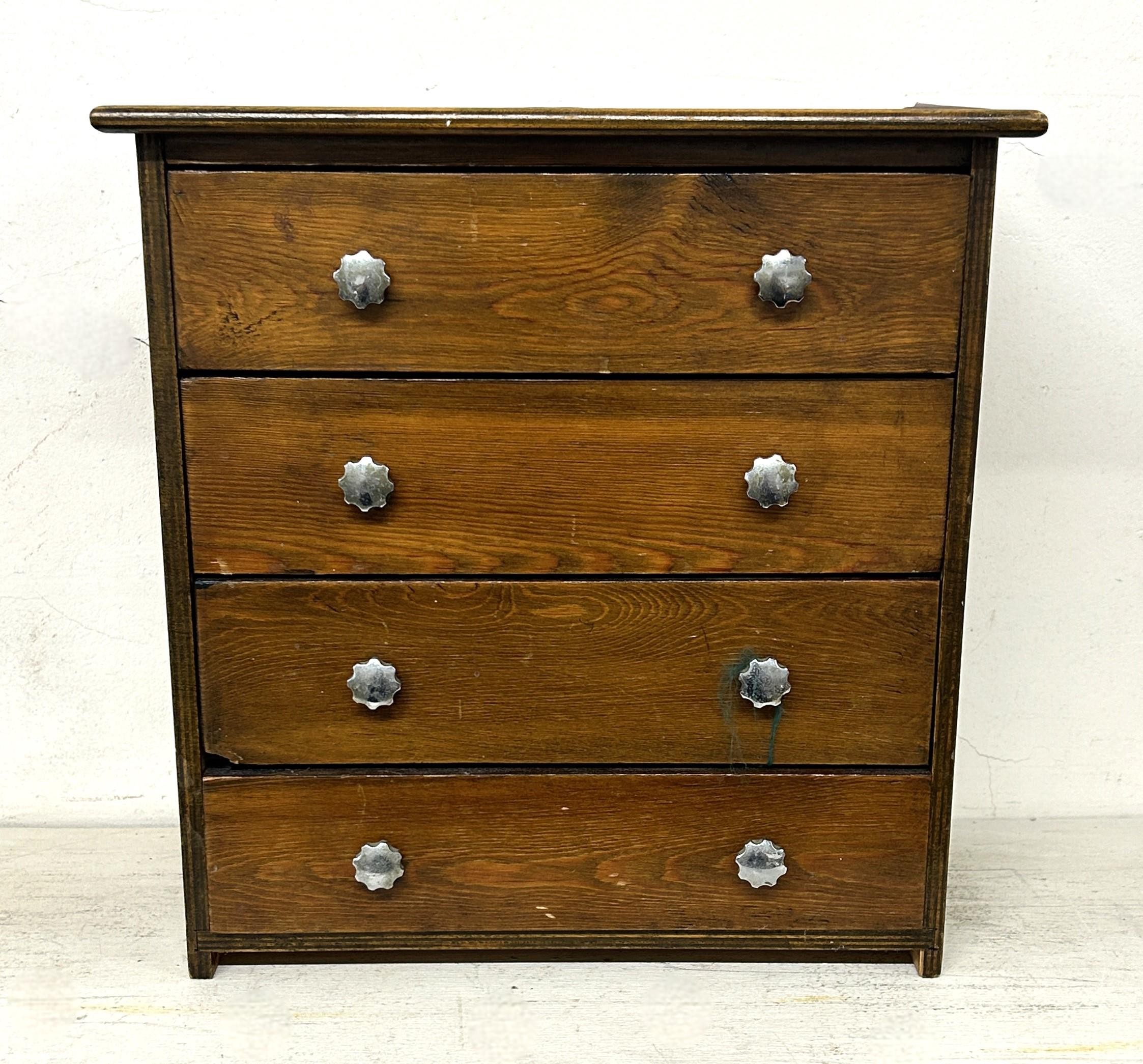 A stained pine table top chest, having four drawers, 30 cm wide