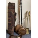 A set of three brass fire irons, two copper warming pans, a red ground rug and a fret framed