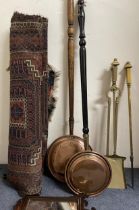 A set of three brass fire irons, two copper warming pans, a red ground rug and a fret framed
