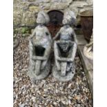 A pair of composite stone planters, of boys pushing wheelbarrows