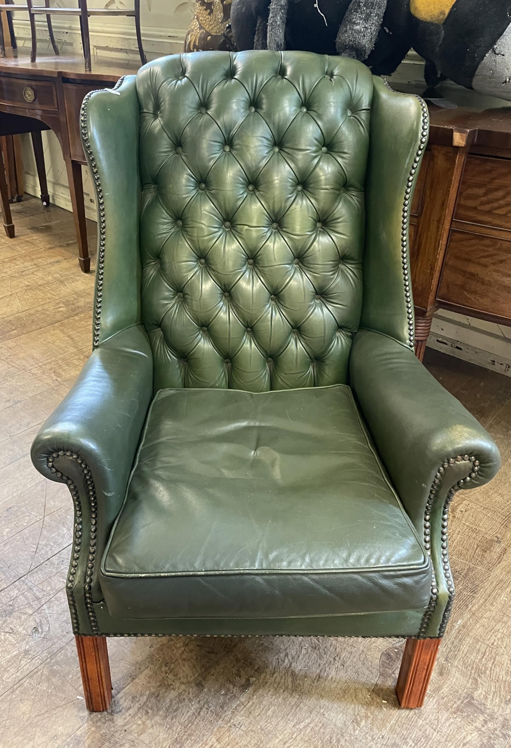 A green wingback button armchair