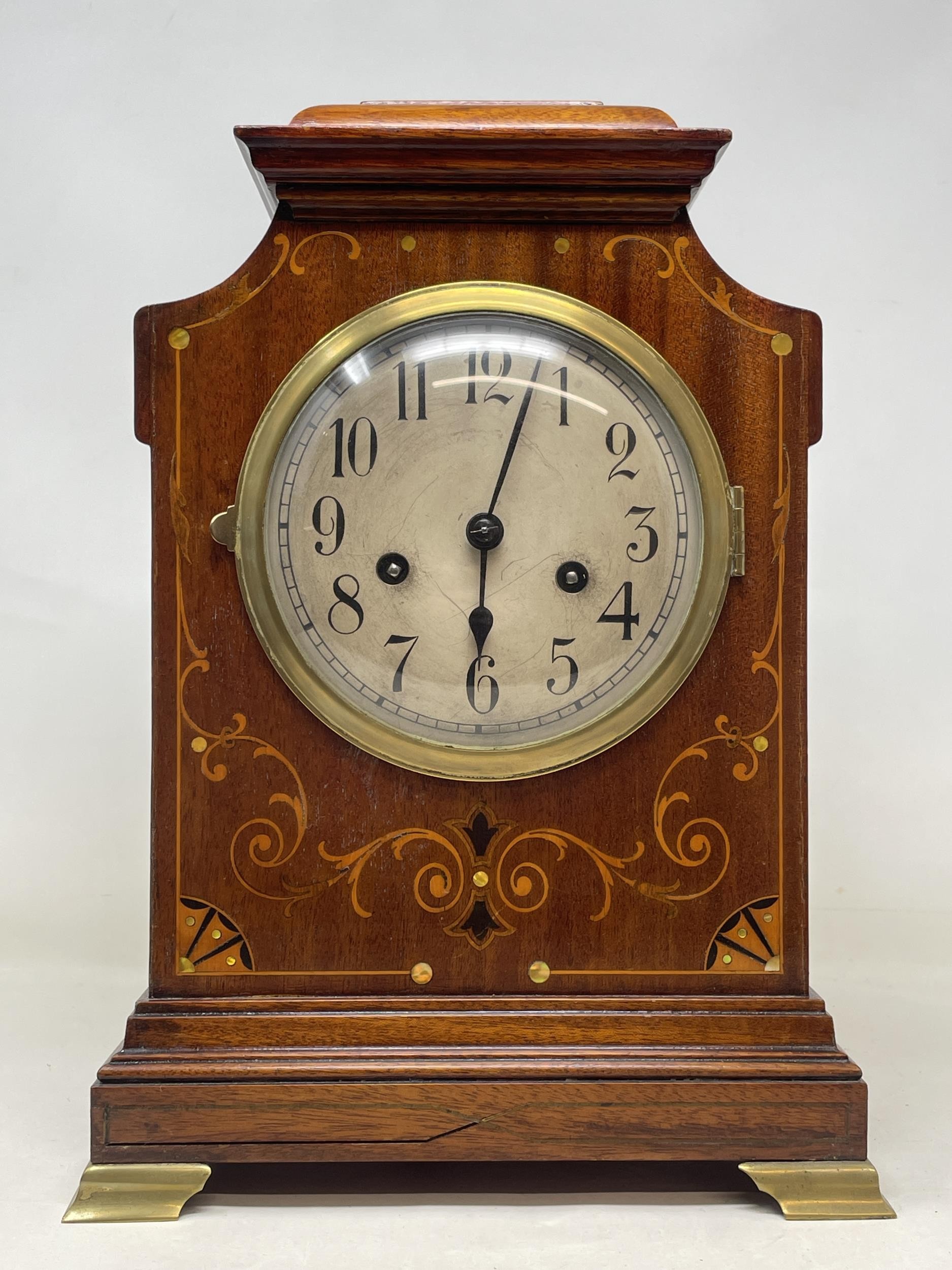 A mantel clock, the silvered dial fitted an eight day movement, striking on a chime, in an inlaid