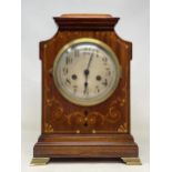 A mantel clock, the silvered dial fitted an eight day movement, striking on a chime, in an inlaid