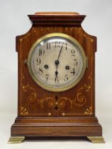 A mantel clock, the silvered dial fitted an eight day movement, striking on a chime, in an inlaid