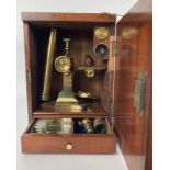 A 19th century brass microscope, in a mahogany case, with a fitted drawer containing various slides