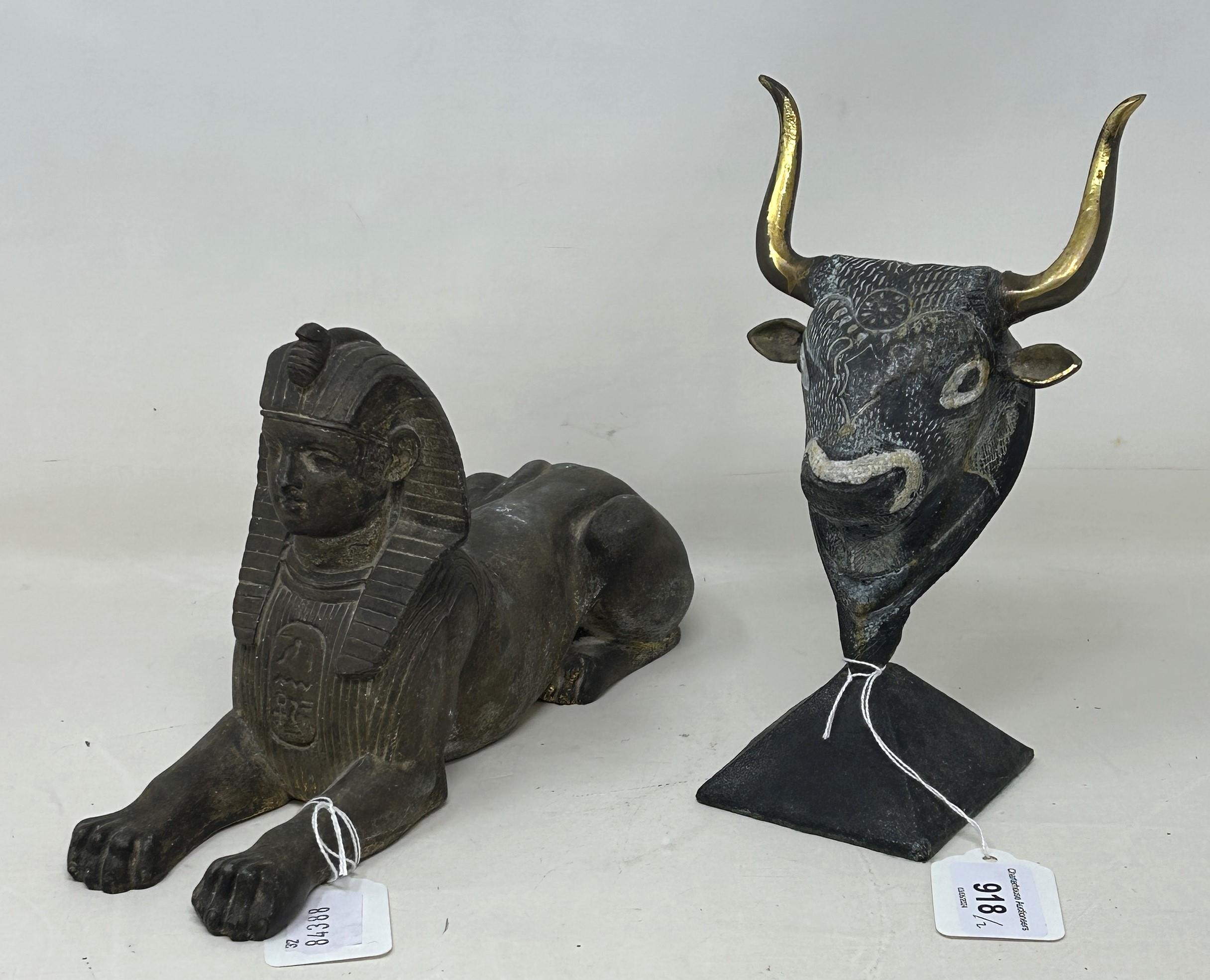 An Egyptian style Sphinx, 25 cm wide, and a figure of a bull's head (2)