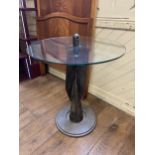 A novelty glass and metal table, in the form of a bomb fin tail, 74 cm diameter