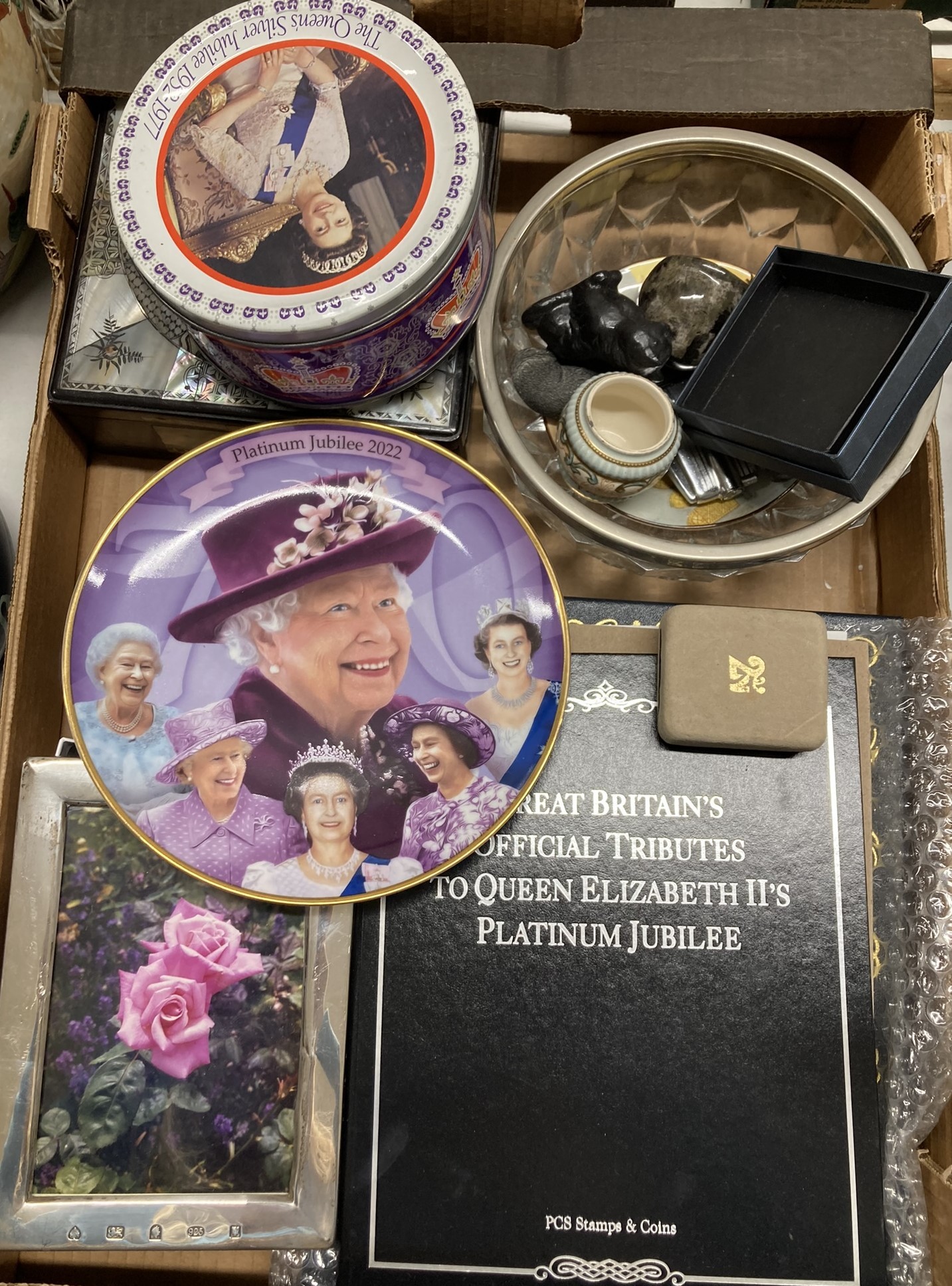 An Elizabeth II silver photograph frame, assorted Queen Elizabeth II commemorative items, and