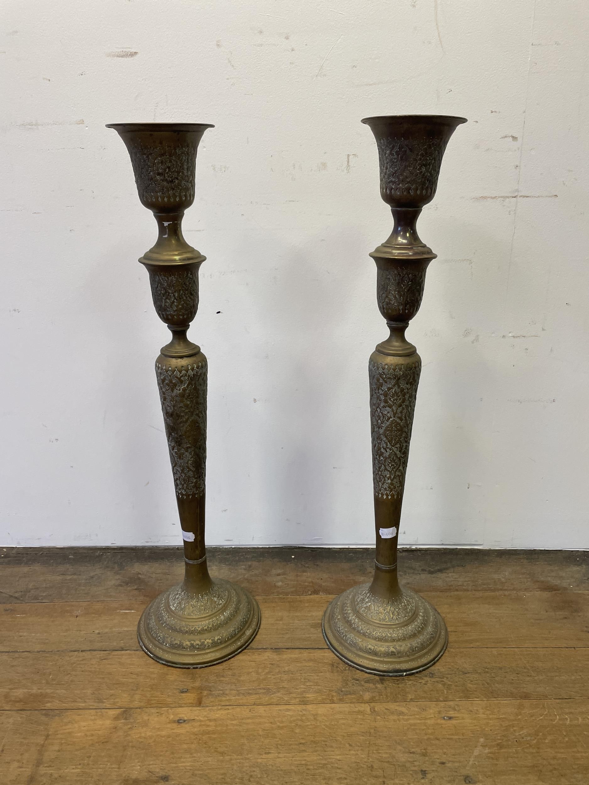 A large pair of Islamic brass candlesticks, 86 cm high