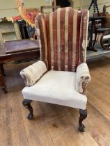 A George III style wingback armchair, on carved cabriole legs to claw and ball feet