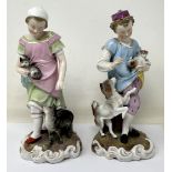 A pair of Dresden figures, of a young boy with a dog and puppy, and a young girl with a cat and