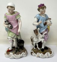 A pair of Dresden figures, of a young boy with a dog and puppy, and a young girl with a cat and
