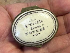 A George III enamel patch box, the lid reading A Trifle From Totnes, 2.4 cm wide some restoration