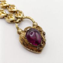 A late 19th/early 20th century yellow metal bracelet, with a padlock clasp, inset with a cabochon