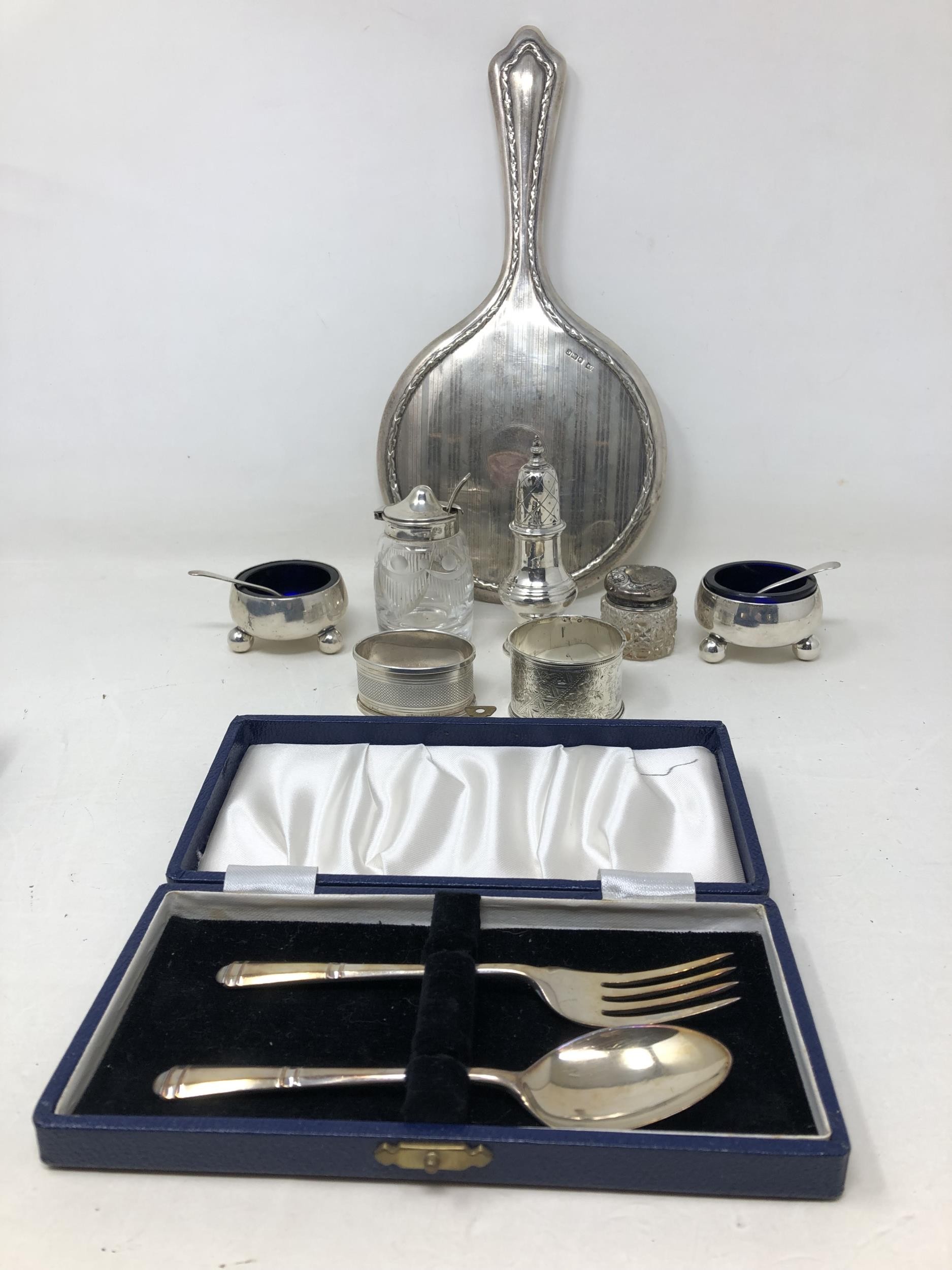 A pair of silver salts, a pepper pot, two napkin rings, a fork and spoon 6.6 ozt, a silver backed