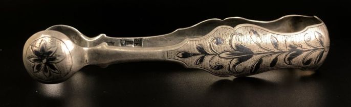 A pair of Continental white metal sugar nips, with niellowork decoration 34.5 g