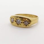 An 18ct gold three stone diamond gypsy set ring, ring size P 1/2 light ware due to use, no obvious