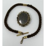 A 19th century hair and gilt metal locket, inset with a lock of hair, flanked by a portrait, and a
