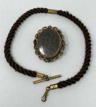 A 19th century hair and gilt metal locket, inset with a lock of hair, flanked by a portrait, and a