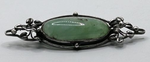 An Arts and Crafts silver coloured metal and green stone brooch by Jean Bassett Provenance:  Descent