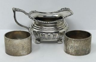 A George V silver cream jug, and two silver napkin rings, various dates and marks, 9.3 ozt (3)