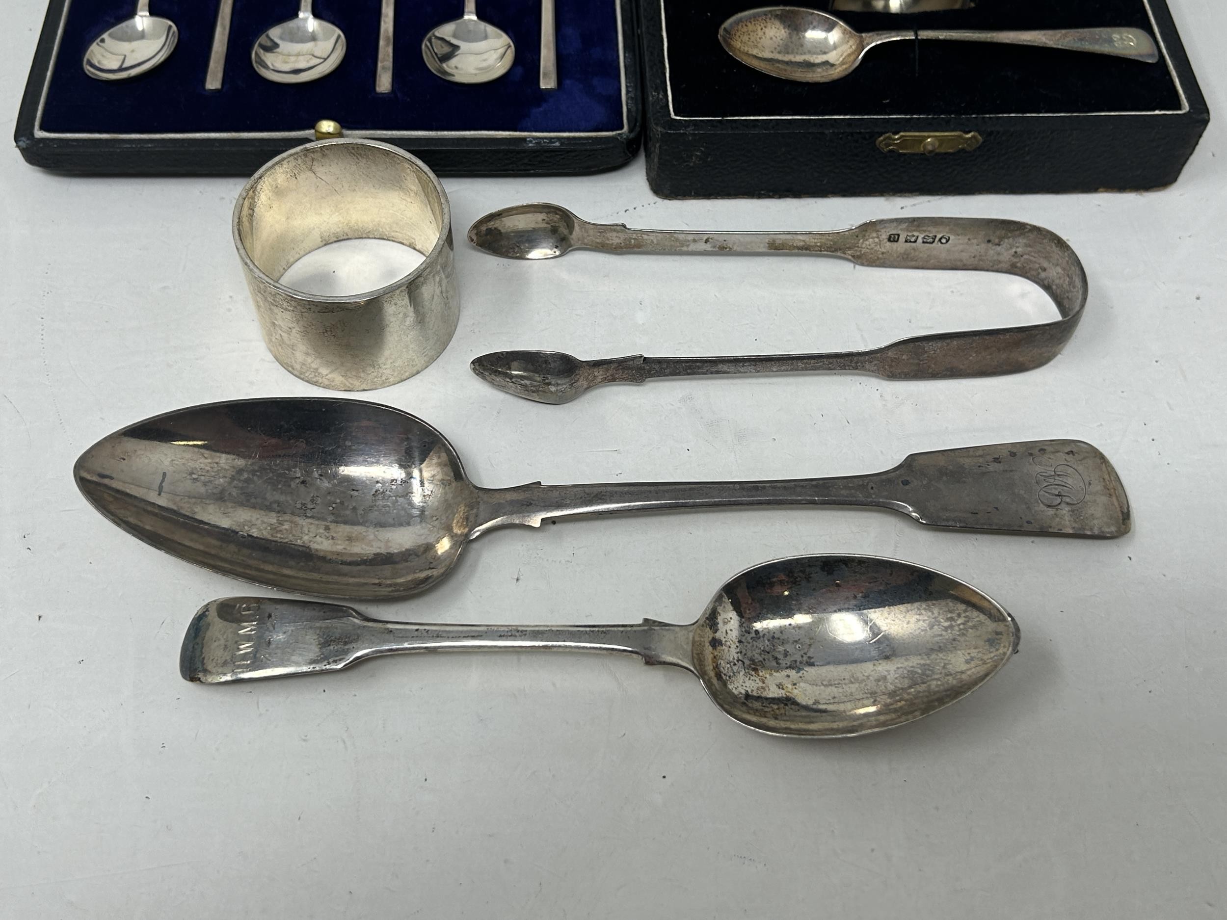 A fiddle pattern spoon, another, a napkin ring, a pair of sugar tongs, an egg cup and spoon, - Image 4 of 7