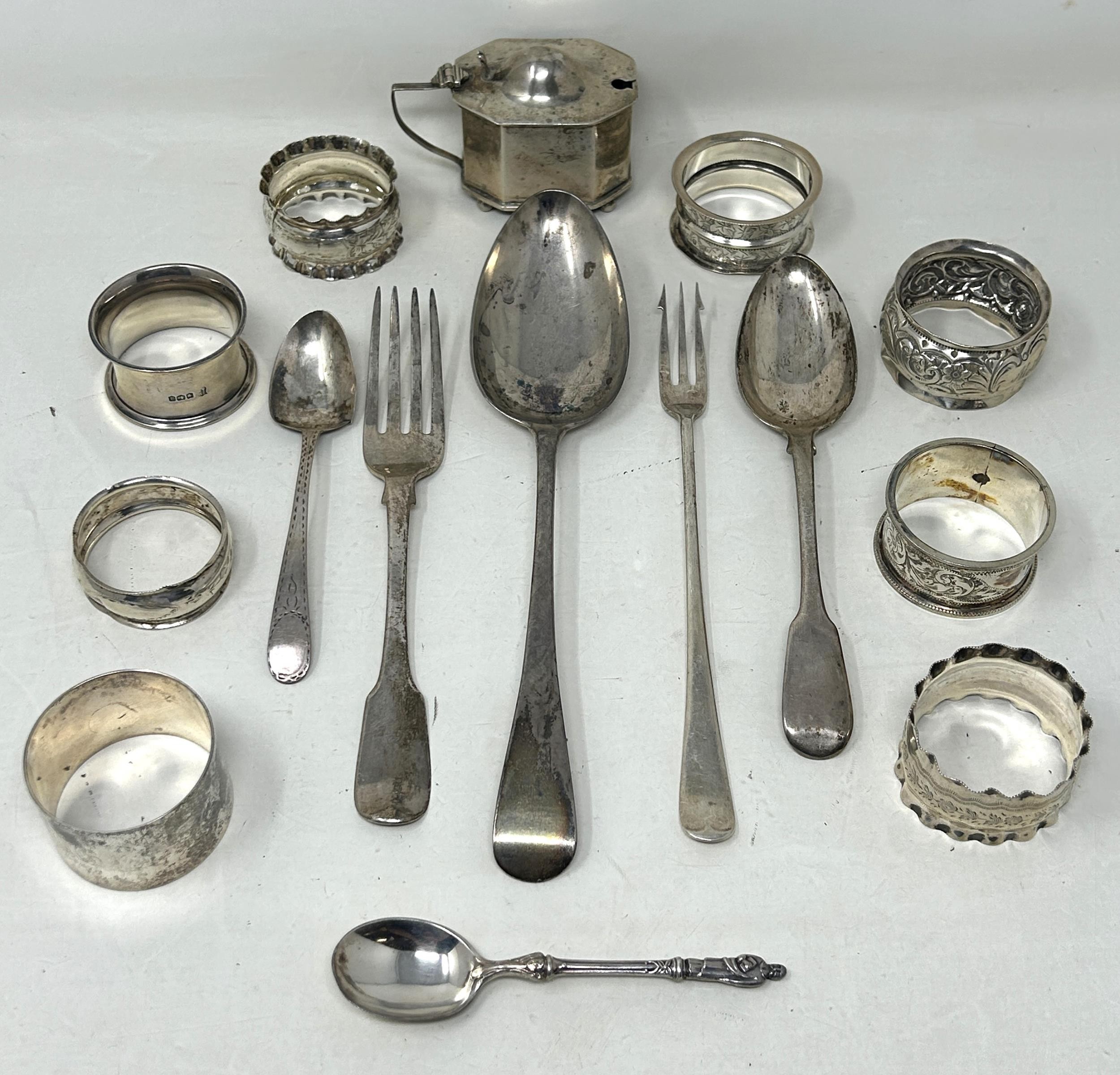 A silver Old English pattern spoon, assorted napkin rings, a mustard pot, and flatware, various