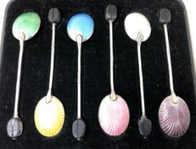 A set of six George V silver and multi-coloured enamel coffee spoons, with carved wooden bean