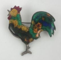 An enamel and silver coloured metal brooch, in the form of a cockerel cracked