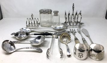 A George V silver tea strainer, 1.5 ozt , two silver topped glass bottles, and assorted silver