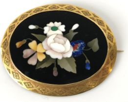 A late 19th/early 20th century pietra dura oval brooch, decorated flowers, in a yellow metal