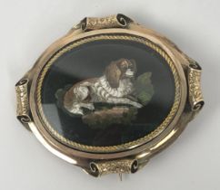 A late 19th century micro-mosaic brooch, decorated a Spaniel, inset in a yellow coloured metal and