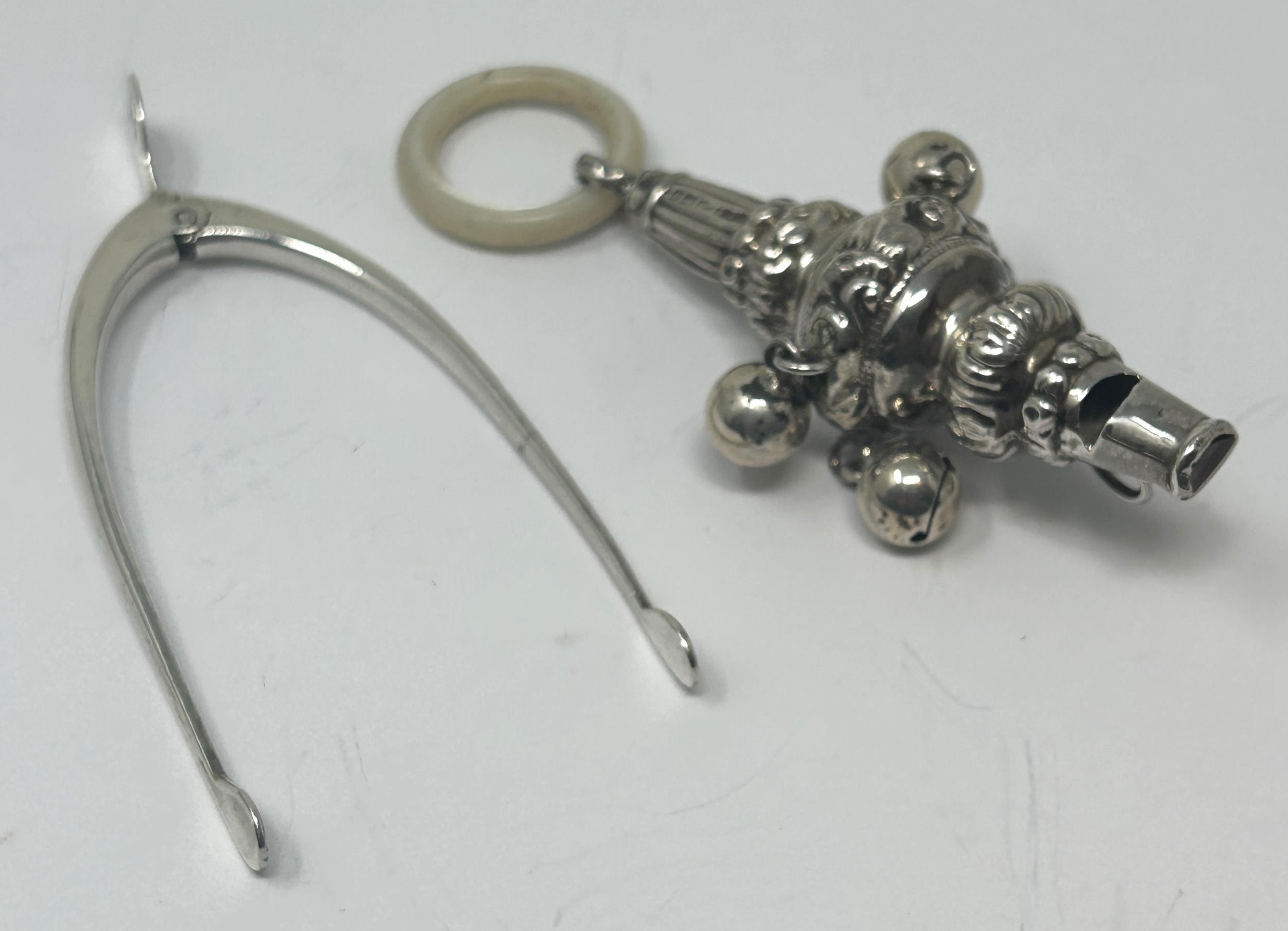 An Edward VII silver and mother of pearl baby's rattle, and a pair of novelty sugar tongs, in the
