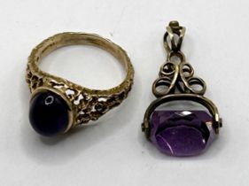 A 9ct gold cabochon cut purple stone ring, ring size N, and a purple stone seal (2)